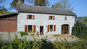 A stone house with a sloped roof, wooden shutters, and a front door. - Chard'heureux (Somme-Leuze)