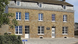 Ein Steinhaus mit zahlreichen Fenstern und einem Schild, das es als Wohnhaus kennzeichnet.