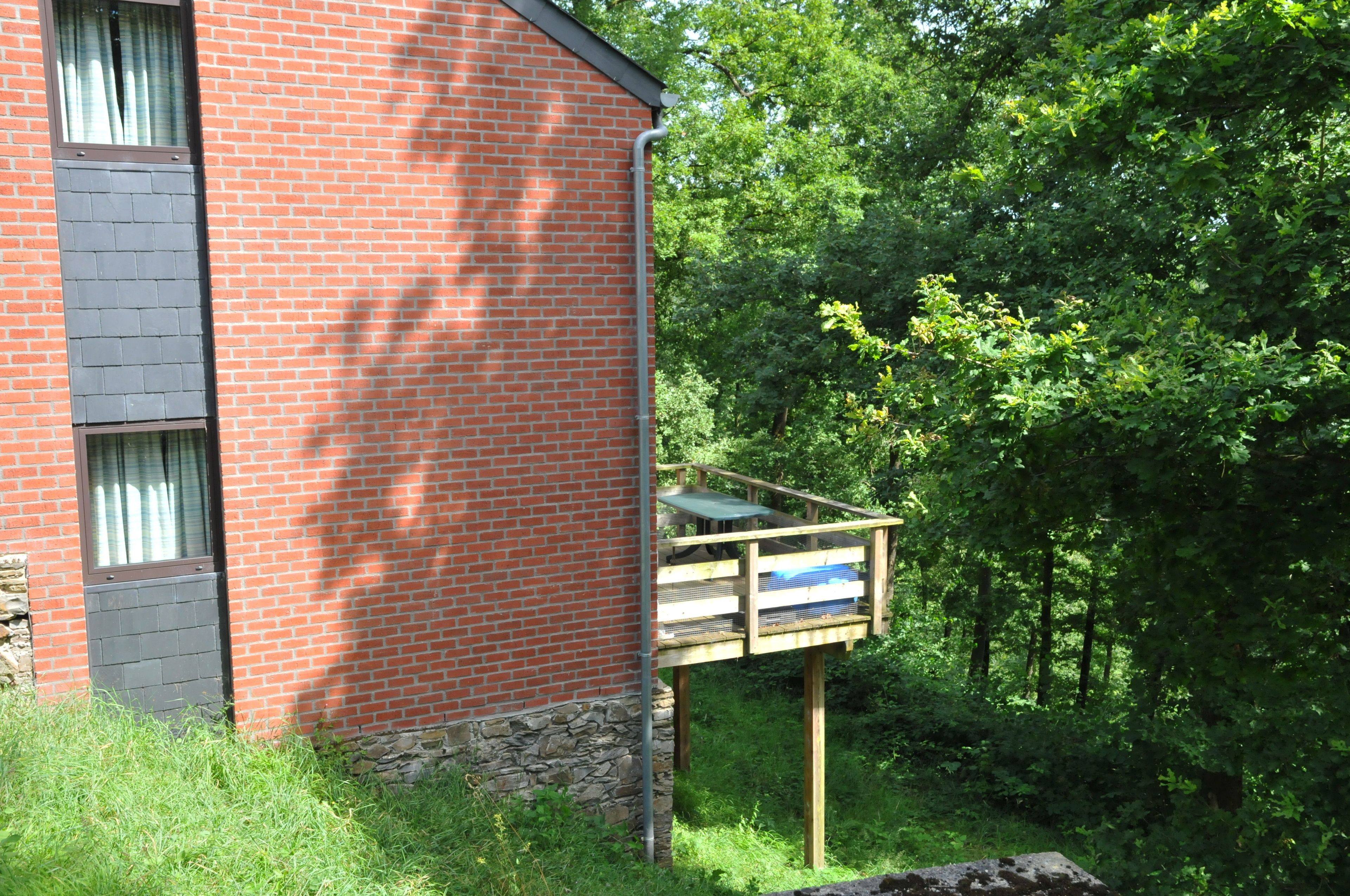 A red brick building with a small deck attached to the side.
