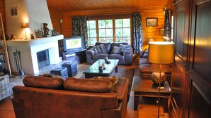 Una sala de estar acogedora con sofás de cuero, una chimenea y un televisor.