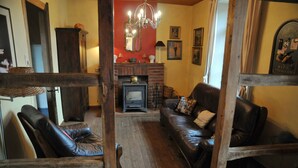 Un salon chaleureux avec une cheminée, des canapés en cuir et une table basse en bois.