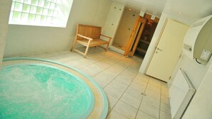 A room with a hot tub, a wooden bench, a tiled floor, and a window with blinds. - Résidence Thier Antoine (Somme-Leuze)