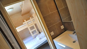 A small, compact bedroom with a wooden bed frame, a white sink, and a mirror in a bathroom. - Rochettes - Mars (La Roche-en-Ardenne)