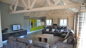 A spacious living area with a modern kitchen in the background, a large sofa set, and a wooden coffee table. - Rochettes - Mars (La Roche-en-Ardenne)