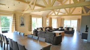 A spacious living area with a large wooden ceiling, a dining table with chairs, and a sofa set. - Rochettes - Mars (La Roche-en-Ardenne)