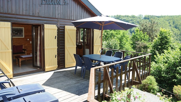 A wooden cabin with a deck, a table with chairs, and an umbrella. - Rochettes - Pluton 3 (La Roche-en-Ardenne)