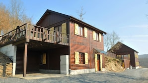 A two-story wooden building with a balcony, a garage, and a small adjacent structure. - Rochettes - Pluton 3 (La Roche-en-Ardenne)