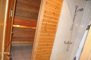 A wooden interior with a shower area, including a showerhead and a handheld shower attachment. - Rochettes - Pluton 4 (La Roche-en-Ardenne)