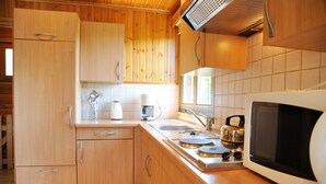 A kitchen with wooden cabinets, a microwave, a kettle, and a coffee maker. - Rochettes - Pluton 4 (La Roche-en-Ardenne)
