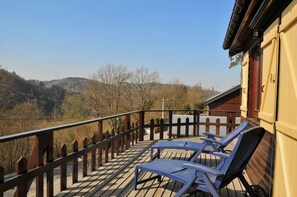 A wooden deck with two lounge chairs, a wooden fence, and a view of a hilly landscape. - Rochettes - Vénus 1 (La Roche-en-Ardenne)