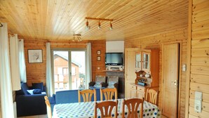 A wooden cabin with a dining area, a sofa, and a television. - Rochettes - Vénus 1 (La Roche-en-Ardenne)