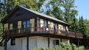 A wooden cabin with a balcony, surrounded by trees. - Rochettes - Vénus 1 (La Roche-en-Ardenne)