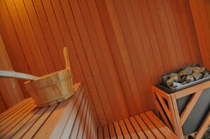 A sauna room with wooden benches and a wooden bucket. - Stone Lodge (Bastogne)