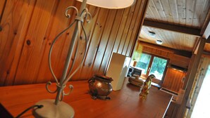 Un intérieur en bois avec une lampe de table, un pot et une cheminée.
