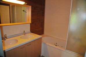 A bathroom with two sinks, a mirror, and a bathtub. - Unité (Houyet)