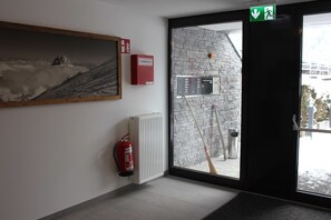 Una habitación con extintor, radiador, un cuadro y vistas al exterior.