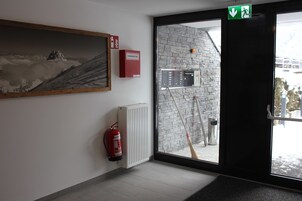Una habitación con extintor, radiador, un cuadro y vistas al exterior.