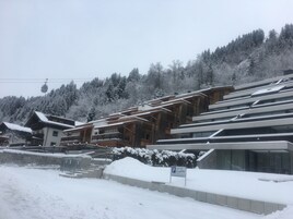 Un complejo de esquí con edificios de madera, un telesilla y árboles cubiertos de nieve.