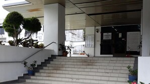 Una entrada de edificio moderna con una escalera que conduce a un espacio cubierto.