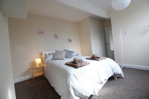 A bedroom with a bed, bedside table, and a mirror. - 2 Bedroom Family Home near Leeds City Center (Leeds)