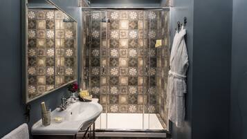 A bathroom with a shower, a sink, and a mirror.