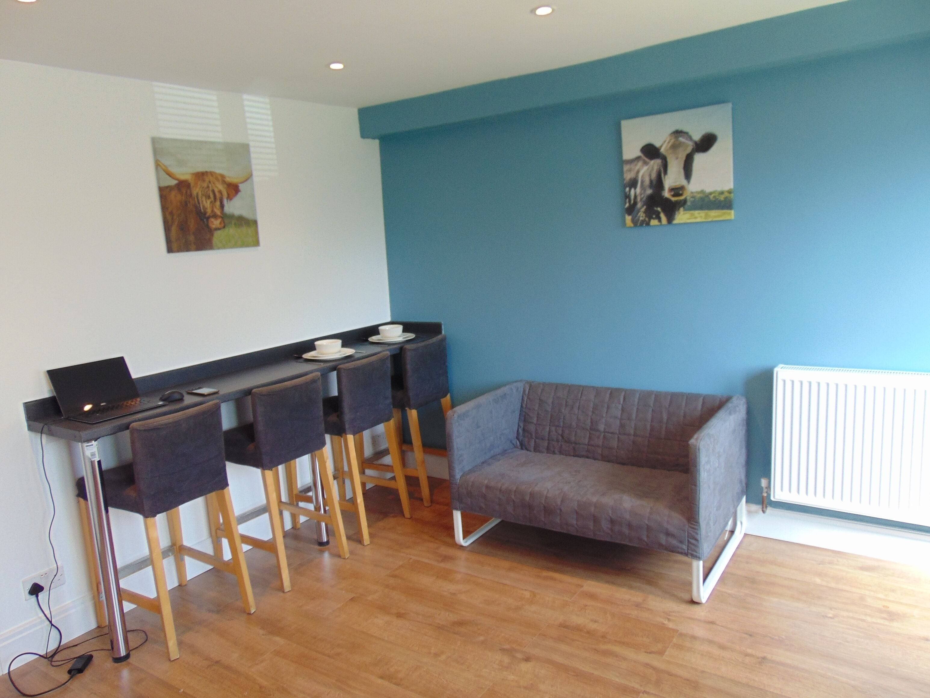 Een moderne keuken met een eethoek, met een bar, stoelen en een bank.