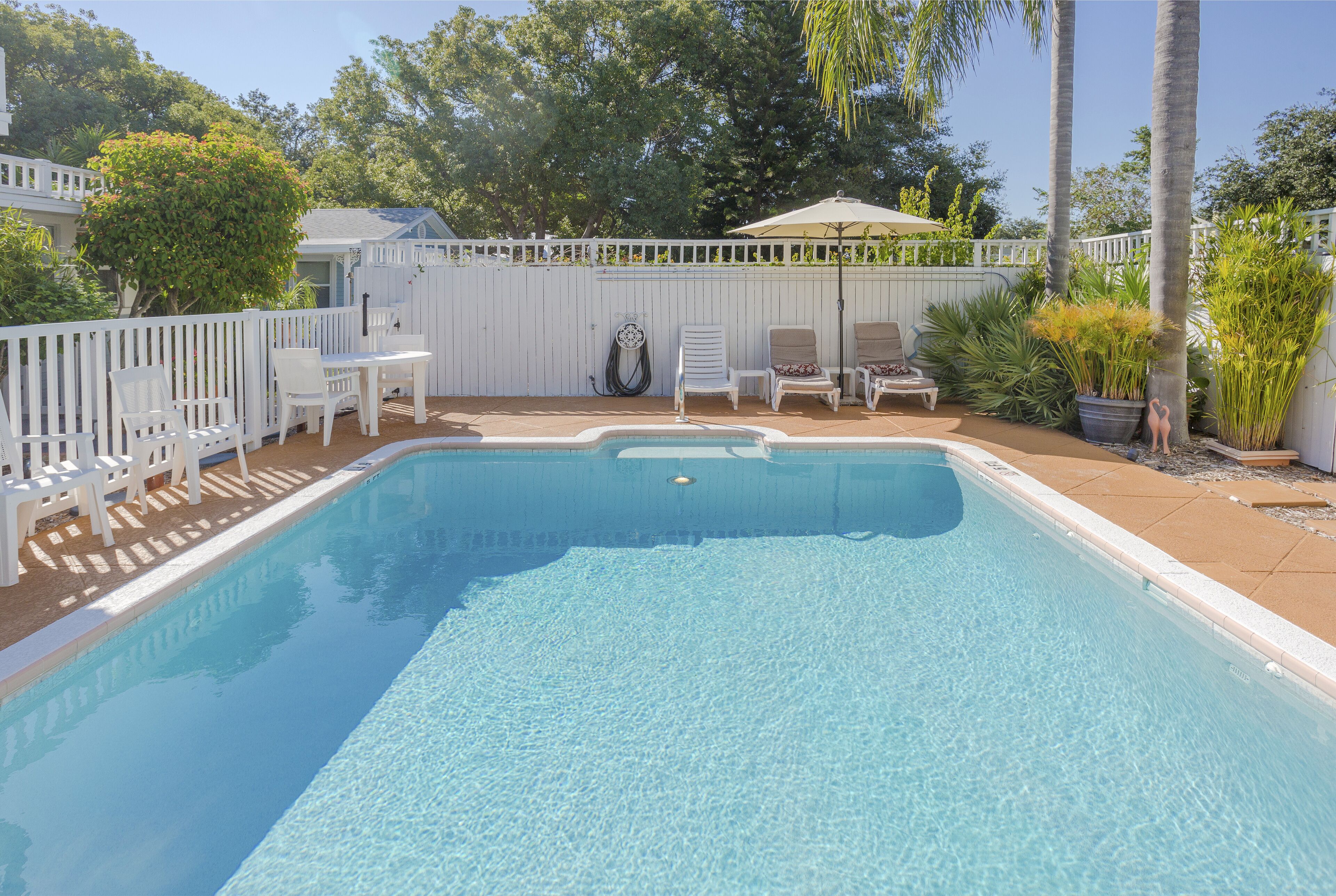 Una piscina al aire libre, sombrillas, tumbonas