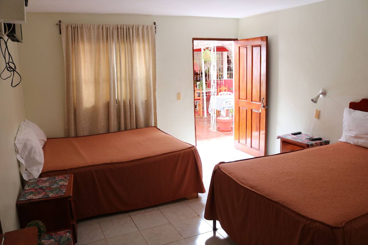 Ein Hotelzimmer mit zwei Betten, einem kleinen Tisch und einem Stuhl.
