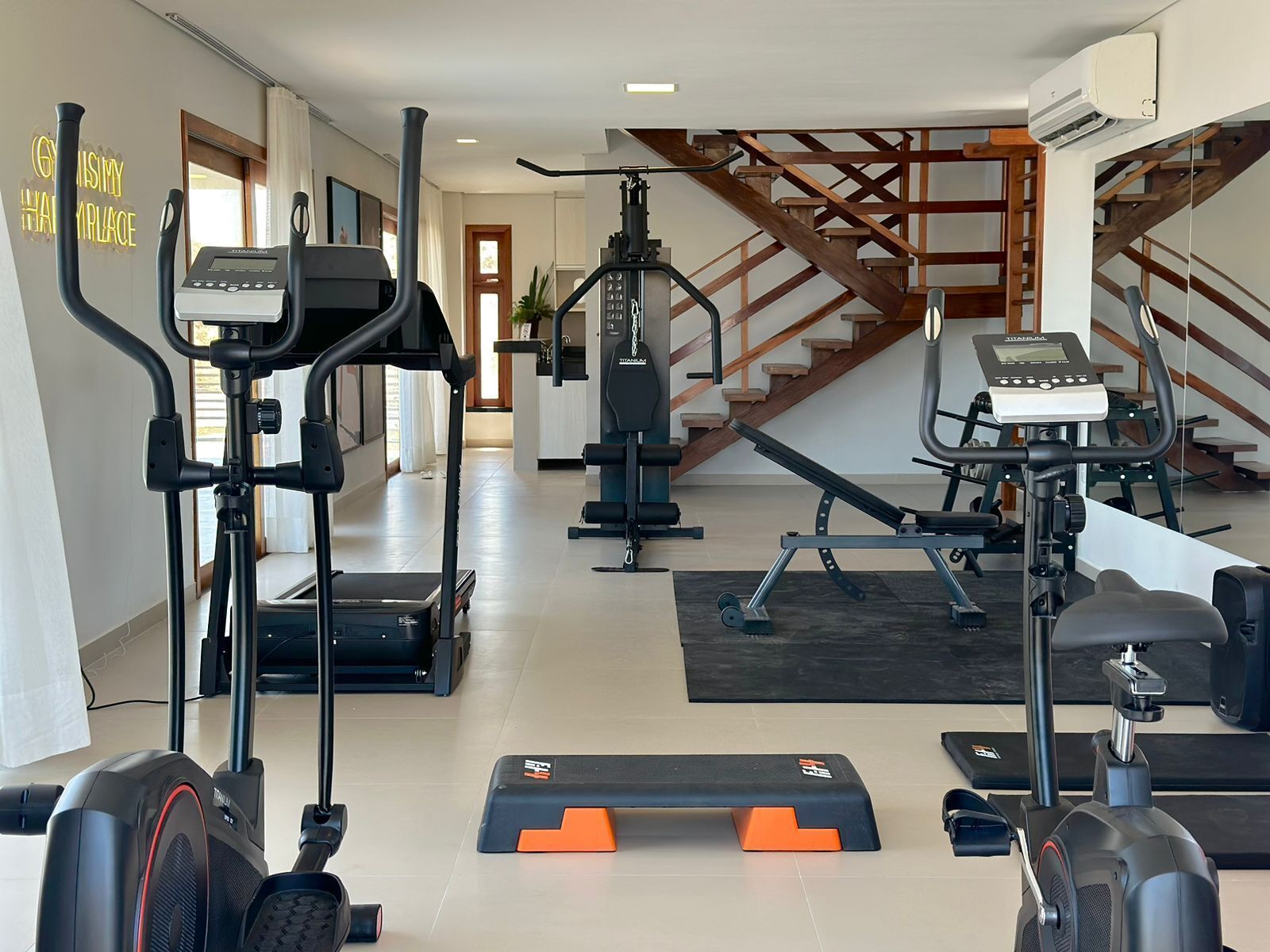 A home gym with treadmills, a stationary bike, and weight machines.