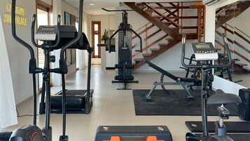 A home gym with treadmills, a stationary bike, and weight machines.