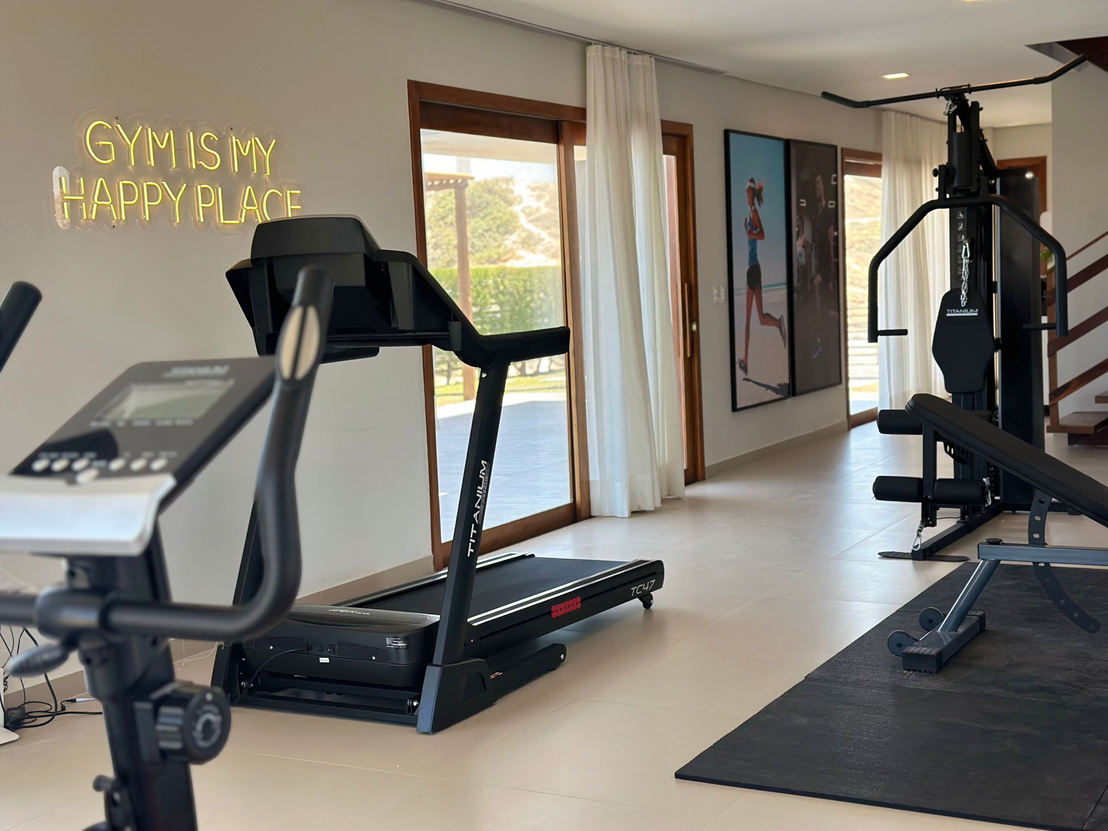 Un gimnasio con cintas de correr, una bicicleta estática y máquinas de pesas.