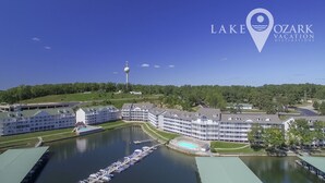 Järvenrantahotelli, jossa on useita rakennuksia, laituri veneineen ja taustalla kohoava torni.