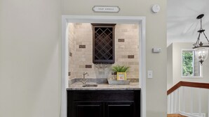 A kitchen with a wine rack, a sink, and a potted plant.