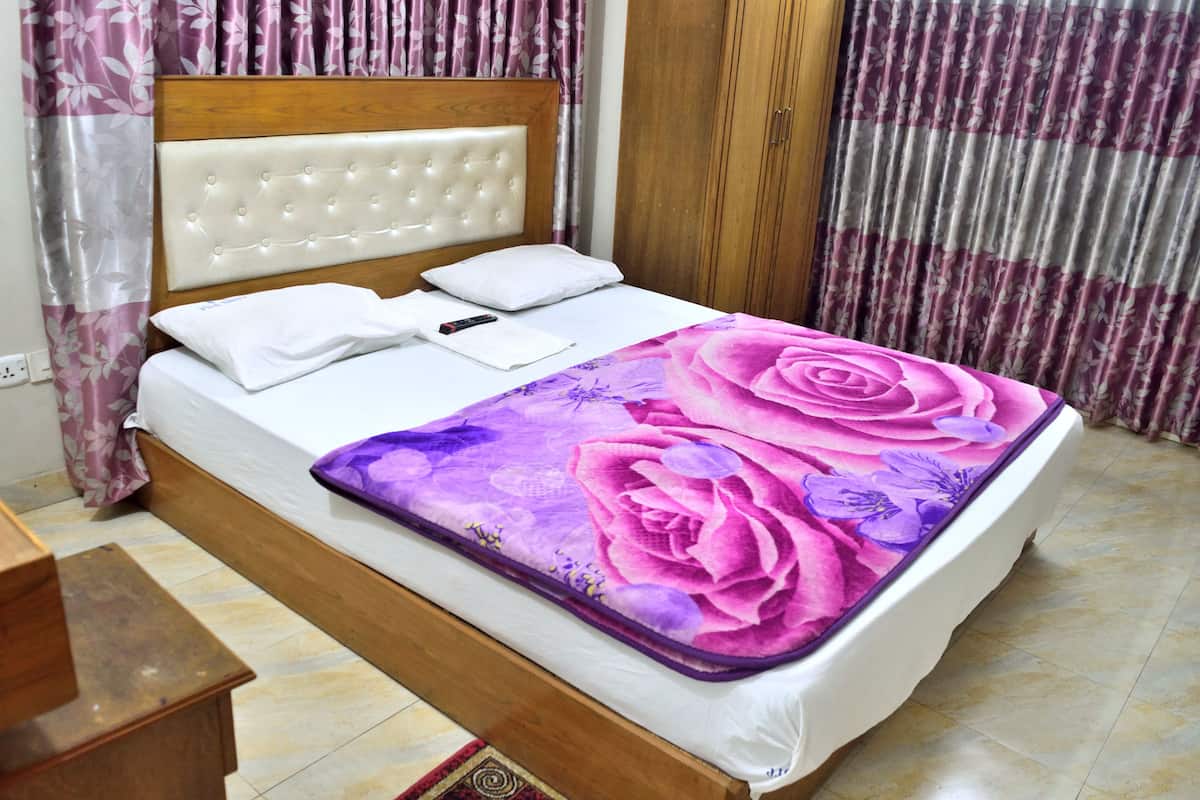 A bed with a floral bedspread, a wooden headboard, and white bedding.