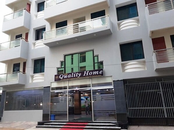 A multi-story building with a sign reading "Quality Home".