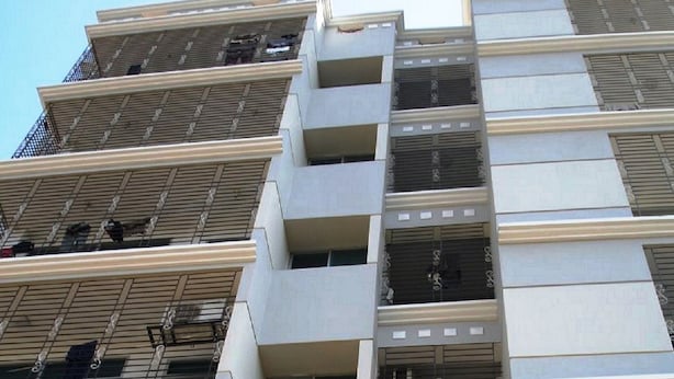 Um edifício com várias andares, varandas e aparelhos de ar condicionado.