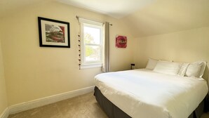 A bedroom with a large bed, a framed picture on the wall, a window with curtains, and a 'DREAM' sign. - Ace Vacation Home at Niagara Falls - Canada (Niagara Falls)