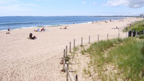 A beach with a sandy shore, a wooden fence, and a clear sky. - Charming Beach Bungalow Near Everything. 3BR, 2 bath.  (Old Orchard Beach)