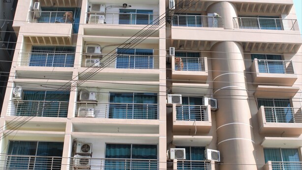 A multi-story hotel with balconies, air conditioning units, and a sign for 'Hotel Delawar Paradise'. - Hotel Delwar Paradise (Cox's Bazar)