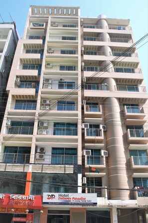 A multi-story hotel with balconies, air conditioning units, and a sign for 'Hotel Delawar Paradise'. - Hotel Delwar Paradise (Cox's Bazar)