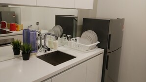 A modern kitchen with white cabinets, a stainless steel sink, a dish drying rack, and a refrigerator. - "5 STAR & LUXURY 2 Bedrooms" in KLCC/KL CityCentre (Kuala Lumpur)