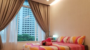 A hotel room with a large bed, beige curtains, a view of a tall building, and a bedside table with a lamp. - "5 STAR & LUXURY 2 Bedrooms" in KLCC/KL CityCentre (Kuala Lumpur)