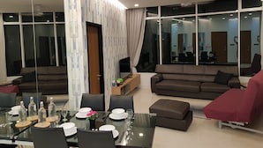 A modern living room with a glass dining table, brown sofas, and a large mirror reflecting the room. - "5 STAR & LUXURY 2 Bedrooms" in KLCC/KL CityCentre (Kuala Lumpur)