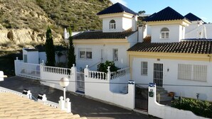 A white building with a tiled roof and a small tower.