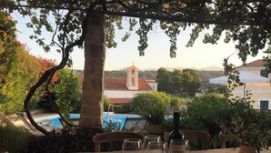 Ein Tisch mit Weingläsern und einer Flasche, draußen aufgestellt mit Blick auf Gebäude und eine Kirche im Hintergrund.