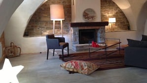 Een gezellig loft slaapkamer met een stenen openhaard, een comfortabele fauteuil en een lamp in de vorm van een ster.