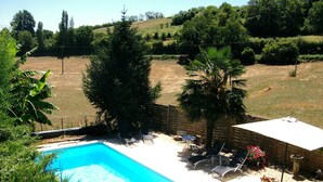 A swimming pool with lounge chairs and a table, surrounded by a fence and greenery. - Country Cottage + Fabulous Views. PRIVATE Exclusive Pool.  WIFI.  Pets Welcome! (Ayen)