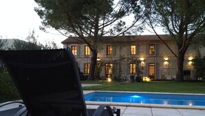 A poolside area with lounge chairs and a stone building in the background. - House with character (Montségur-Sur-Lauzon)