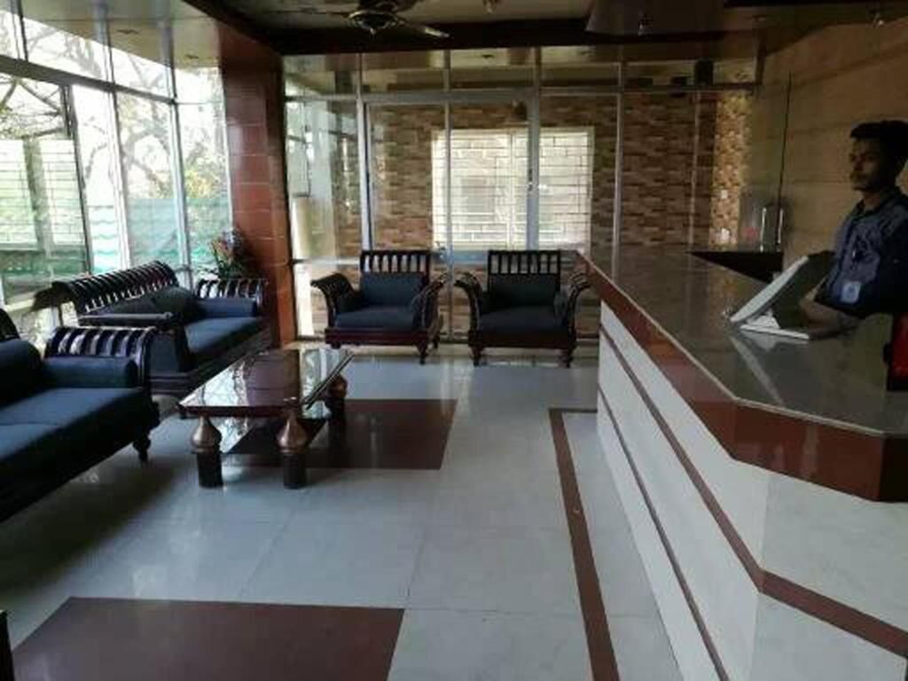 A lobby with seating areas, a reception desk, and large windows.