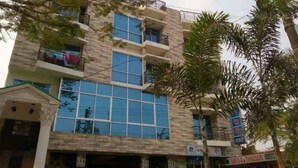 A multi-story building with large windows, balconies, and a sign indicating a restaurant. - Milky Resort (Teknaf)
